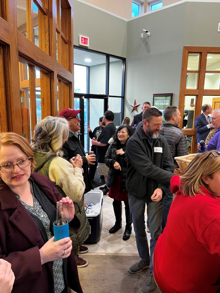 Press Club attendees squeeze into the lobby of a local bank, which is also a sponsor of the club, for a Thursday night mingle.